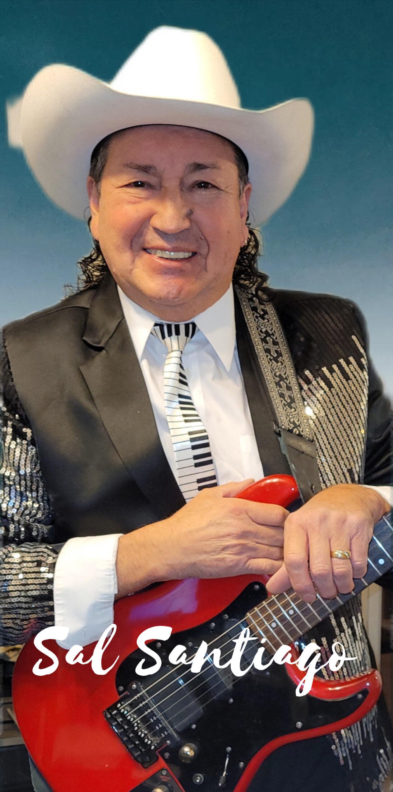 Sal Santiago in cowboy hat with red guitar and sequined jacket
